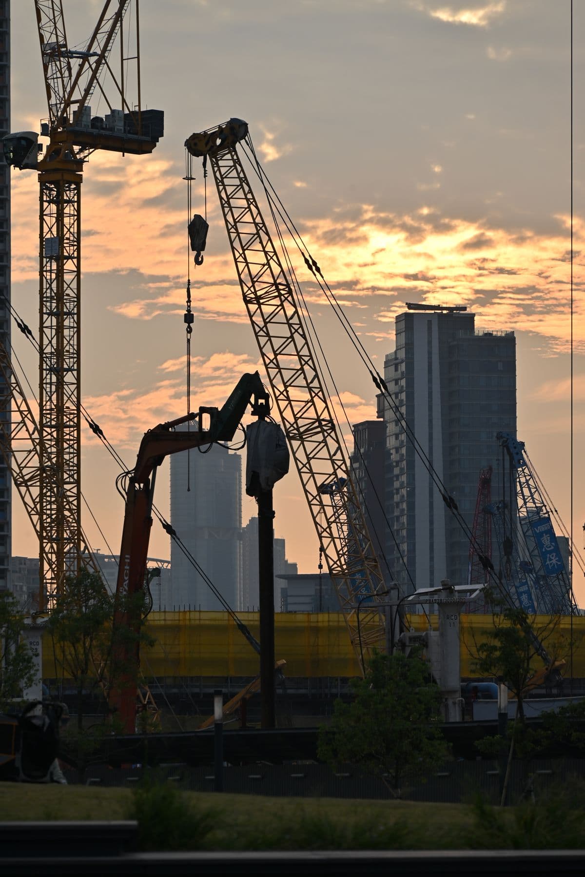 Urban construction site at dusk with tower cranes — groundbreaking in Gulberg, Lahore